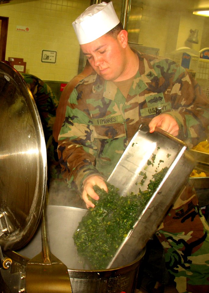 US Navy 080121-N-8547M-055 Culinary Specialist 3rd Class Jesus D. Fimbres, assigned to Naval Mobile Construction Battalion (NMCB) 5, cooks vegetables for the Martin Luther King Jr. memorial dinner