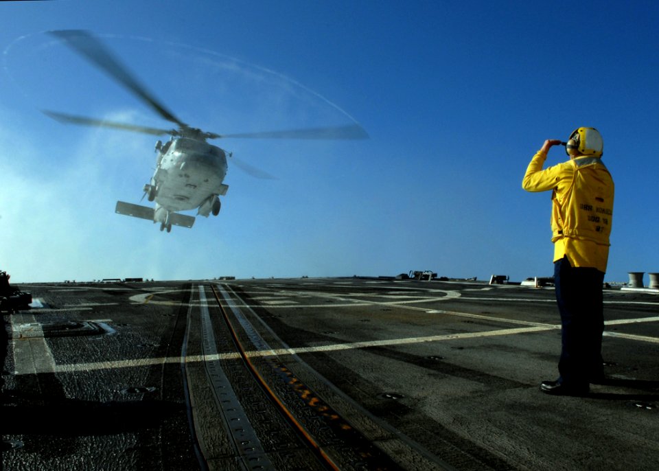 US Navy 080127-N-7981E-047 Boatswain's Mate 1st Class William Geurin signals the SH-60F Seahawk carrying Secretary of the Navy (SECNAV) The Honorable Dr. Donald Winter to a landing aboard the Arleigh Burke-class guided-missile