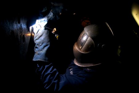 US Navy 080125-N-7955L-172 Hull Maintenance Technician 3rd Class Marc Kaski welds a piece of steel in the hull maintenance technician shop aboard the amphibious assault ship USS Kearsarge (LHD 3)
