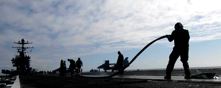 US Navy 080128-N-1229B-141 Aviation boatswain's mates (Equipment) from the air department aboard the Nimitz-class aircraft carrier USS Abraham Lincoln (CVN 72) lay down a rubber cover on a steam catapult track
