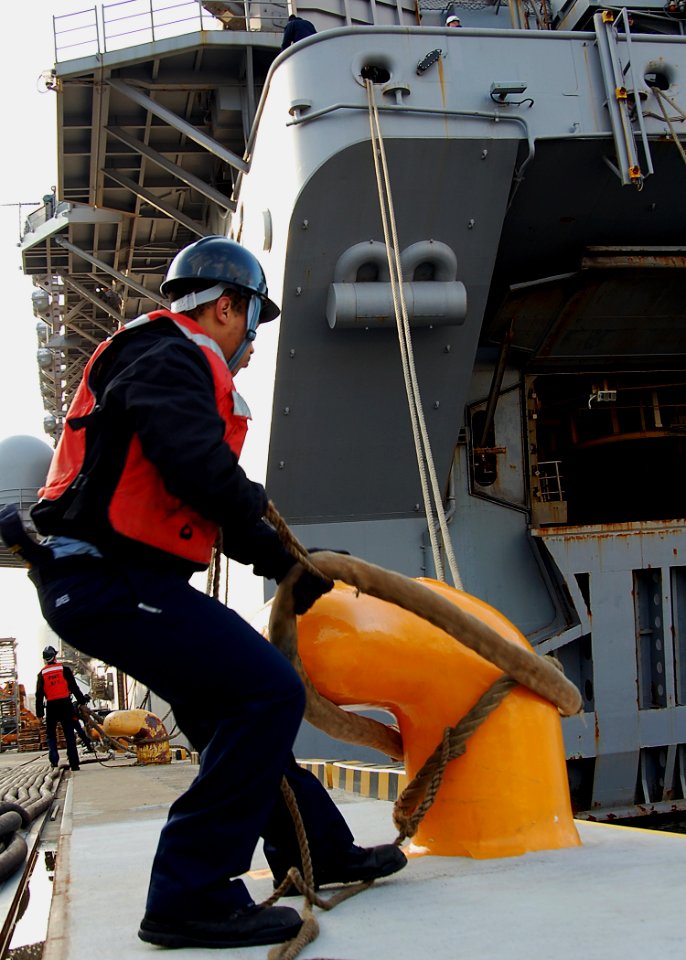 US Navy 080124-N-6710M-005 Engineman 3rd Class Donald Jones releases a mooring line as the amphibious assault ship USS Essex (LHD 2) prepares to get underway from Sasebo, Japan
