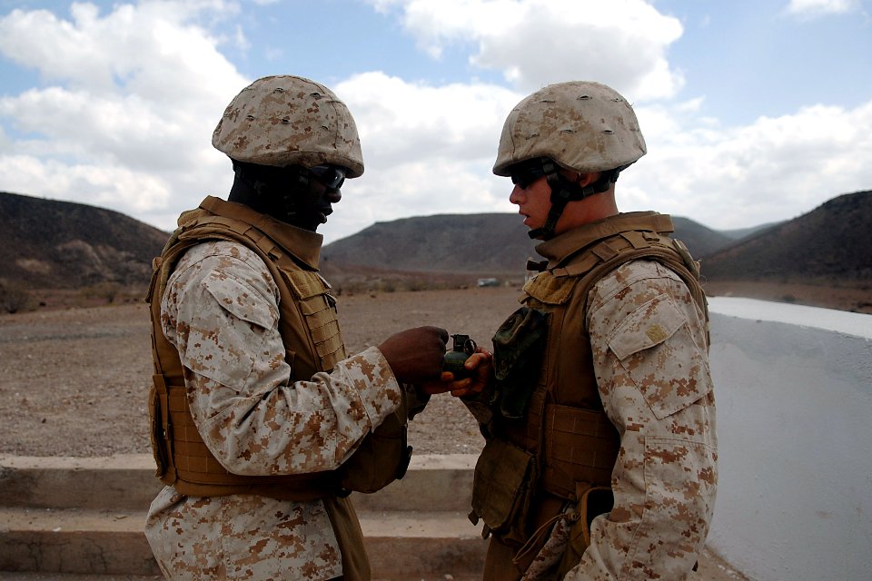 US Navy 080123-F-1644L-051 Sgt. Paul Clark assigned to the 3rd Low Altitude Air Defense Battalion, instructs Lance Cpl. Elbert O'Neal before he throws a M-67 Fragment Grenade at the firing range