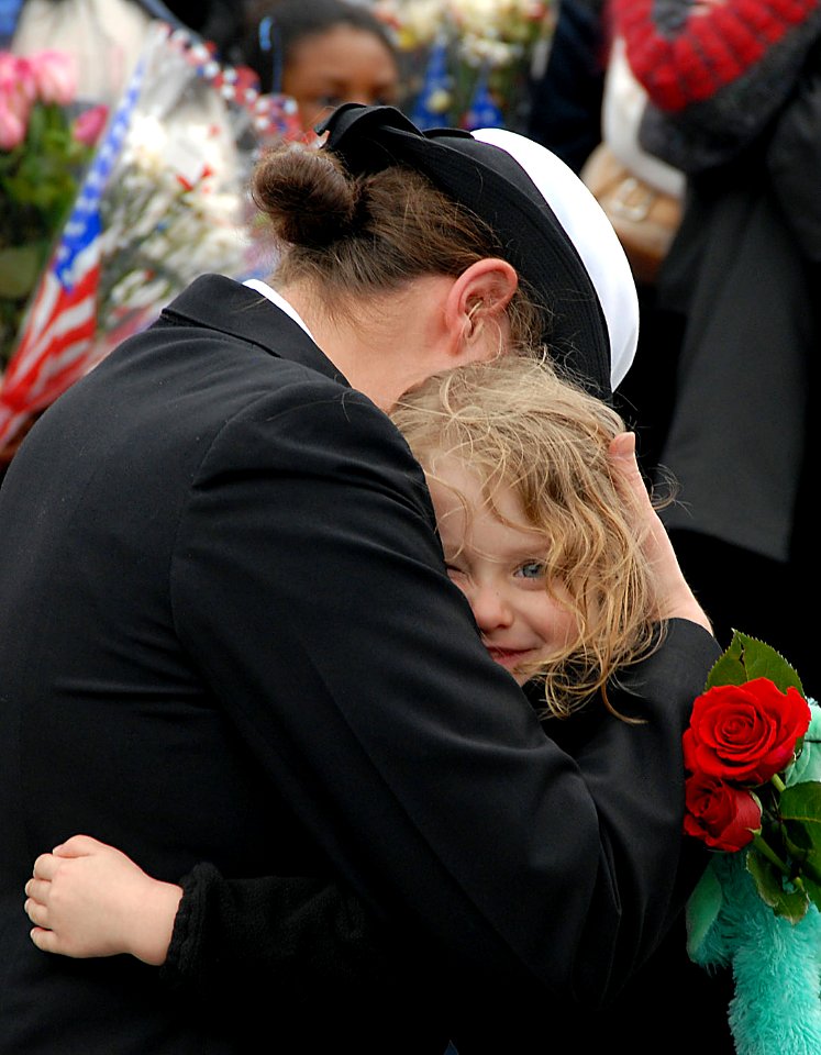 US Navy 080201-N-1831S-199 A Sailor from the amphibious assault ship USS Kearsarge (LHD 3) embraces her daughter after returning from a six-month deployment as part of the Kearsarge Expeditionary Strike Group (ESG)