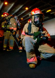 US Navy 080130-N-7981E-089 Ship's Serviceman 3rd Class Anthony Brown leads a hose team during a simulated fire during a general quarters drill in the hangar bay of the Nimitz-class aircraft carrier USS Abraham Lincoln (CVN 72) photo