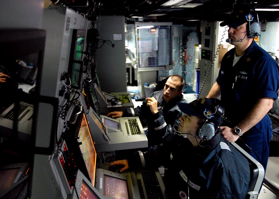 US Navy 080126-N-7981E-825 Sonar Technician (Surface) 1st Class Mark Osborne supervises Sonar Technician (Surface) 2nd Class Randy Loewen, right, and Sonar Technician (Surface) 3rd Class Roland Stout, left, as they monitor cont