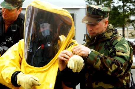 US Navy 080130-N-2143T-002 Explosive Ordnance Disposal Technician 1st Class Matthew Harrison, assigned to Mobile Unit (EODMU) 11 based out of Whidbey Island, Wash., helps Chief Explosive Ordnance Disposal Technician Patty Keil photo