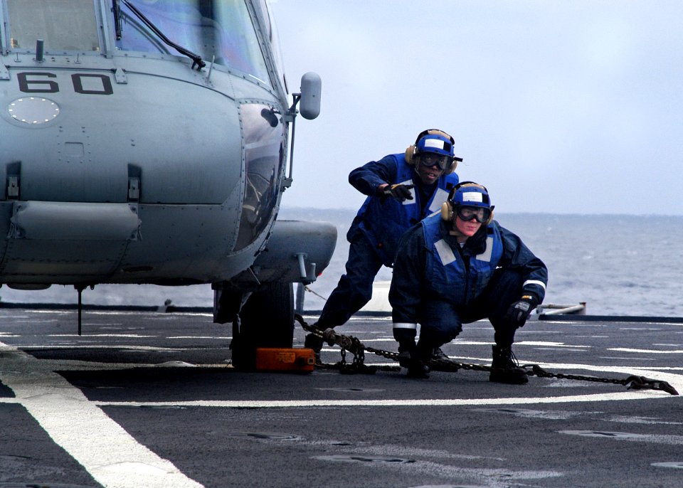US Navy 080203-N-0807W-437 Sailors aboard the amphibious assault ship USS Harpers Ferry (LSD 49) secure an SH-60 Seahawk helicopter to the flight deck
