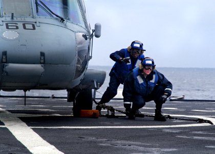US Navy 080203-N-0807W-437 Sailors aboard the amphibious assault ship USS Harpers Ferry (LSD 49) secure an SH-60 Seahawk helicopter to the flight deck