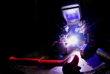 US Navy 080205-N-9760Z-004 Hull Maintenance Technician 2nd Class Russell Roemer welds a machine part in the repair shop aboard the aircraft carrier USS Nimitz (CVN 68)