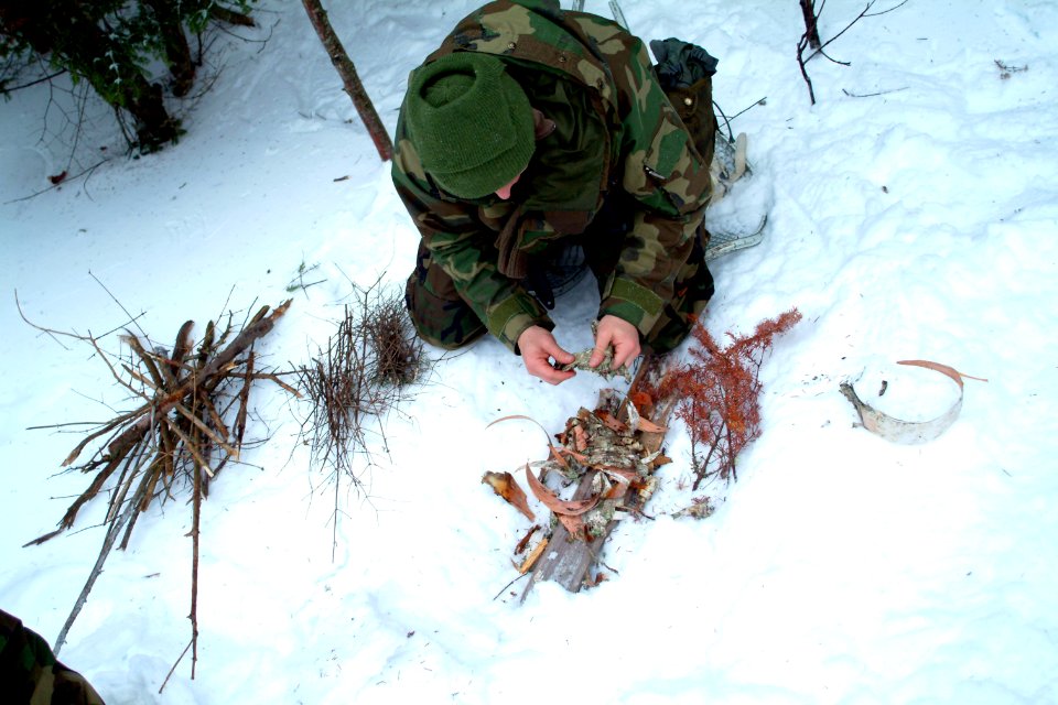 US Navy 080203-N-0411D-019 A student at the Navy Survival, Evasion, Resistance and Escape (SERE) school breaks birch bark to start a fire