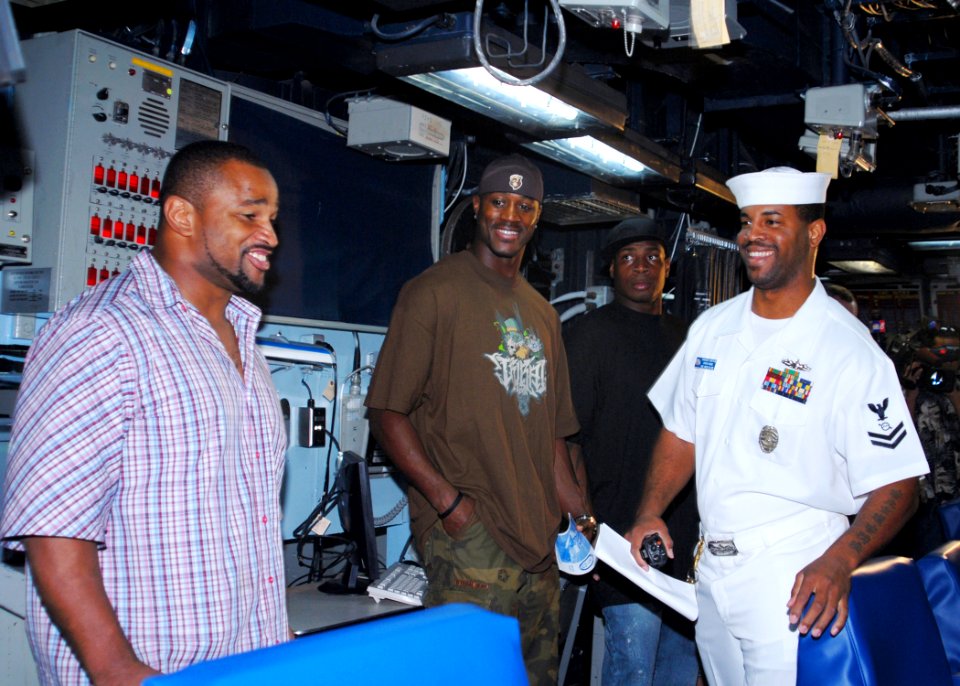 US Navy 080203-N-5476H-021 Operations Specialist 2nd Class Chancer Burton enjoys a joke with Lorenzo Neal, left, fullback for the San Diego Chargers, during a tour of the Ticonderoga-class guided-missile cruiser USS Chosin (CG