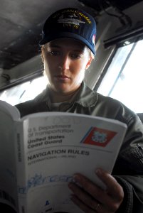 US Navy 080128-N-7526R-008 Lt. Colleen Kosloski studies Coast Guard navigation rules while training for junior officer of the watch during a sea and anchor evolution aboard the Nimitz-class aircraft carrier USS Ronald Reagan (C