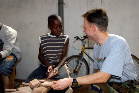 US Navy 080130-N-0193M-080 Musician 1st Class Dan Smith, an Africa Partnership Station (APS) volunteer talks with a young boy at Centre d' Accueil Orphanage