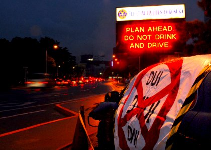 US Navy 080129-N-2638R-002 Vehicles move past a damaged vehicle displaying an anti-drinking and driving message at the main entrance to Fleet Activities Yokosuka