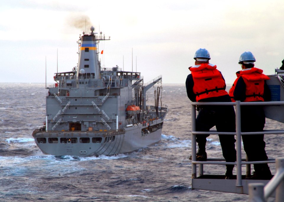 US Navy 080206-N-0807W-053 Two Sailors aboard the dock landing ship USS Harpers Ferry (LSD 49) watch the Military Sealift Command fleet replenishment oiler USNS Pecos (T-AO 197) during a refueling-at-sea