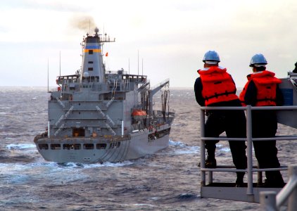 US Navy 080206-N-0807W-053 Two Sailors aboard the dock landing ship USS Harpers Ferry (LSD 49) watch the Military Sealift Command fleet replenishment oiler USNS Pecos (T-AO 197) during a refueling-at-sea