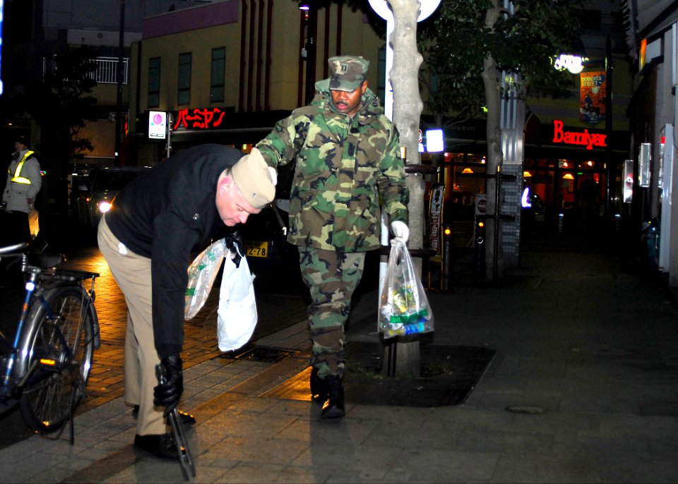 US Navy 080201-N-2638R-003 Cmdr. Jon Lundquist, chief staff officer for the commander of Fleet Activities Yokosuka, and Lt. Paul Bradley, the base security officer, help collect garbage in the Honcho District of Yokosuka