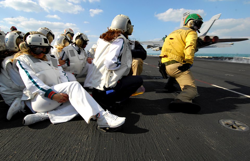US Navy 080202-N-2984R-508 Miami Dolphins cheerleaders watch an F-A-18 Hornet launch from the flight deck of the Nimitz-class aircraft carrier USS Theodore Roosevelt (CVN 71)