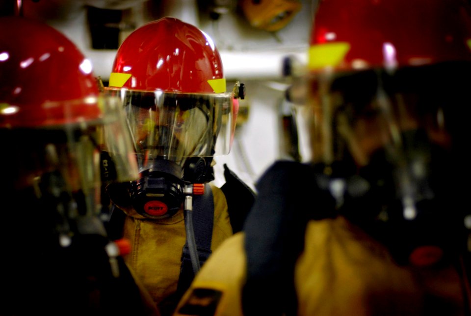 US Navy 080212-N-8546L-121 Damage Control Fireman Weber Roche, center, and members of his hose team look for a hot spot during a main space fire drill in the engine room aboard the USS Blue Ridge (LCC 19)