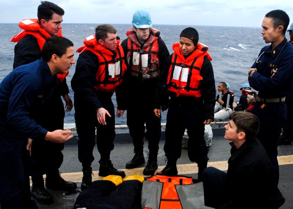 US Navy 080209-N-5067K-044 Lt. Jeremy Moore, medical officer aboard the amphibious transport dock ship USS Juneau (LPD 10), conducts training and quickly briefs the stretcher-bearers prior to moving a simulated patient