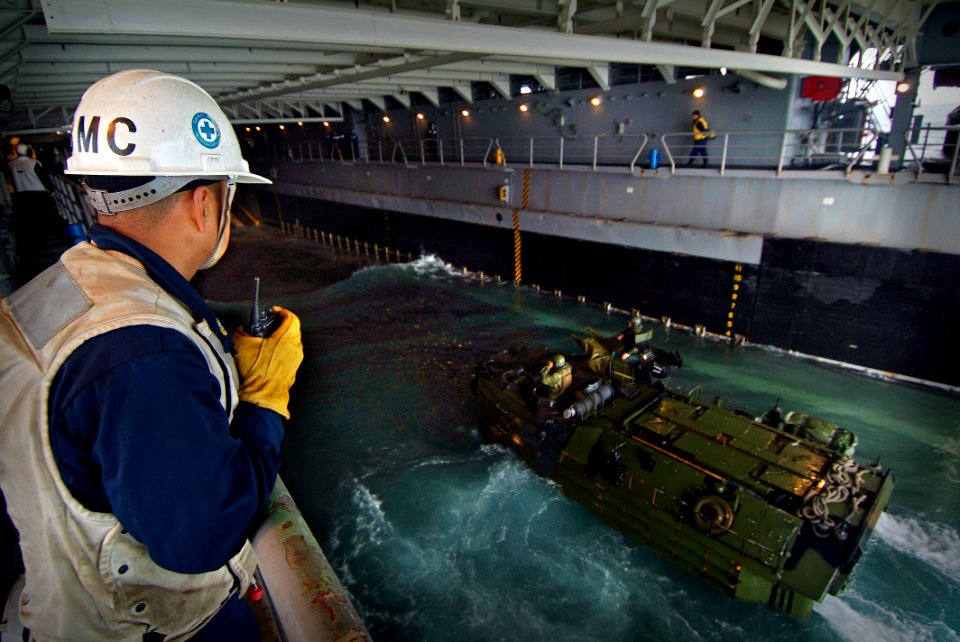US Navy 080203-N-0807W-107 Chief Boatswain's Mate Marvin Guinko watches a Marine armored assault vehicle assigned the 31st Marine Expeditionary Unit enter the well deck of the dock landing ship USS Harpers Ferry (LSD 49)