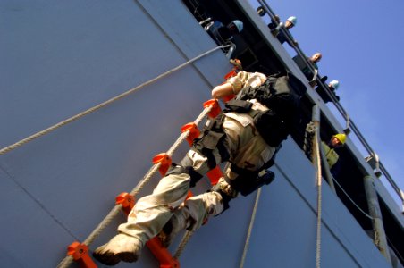 US Navy 080206-N-2420K-062 Sailors from the guided-missile frigate USS Ingraham (FFG 61) watch as a member of the ship's visit, board, search and seizure team descends a Jacobs ladder into a rigid hull inflatable boat to inspec photo