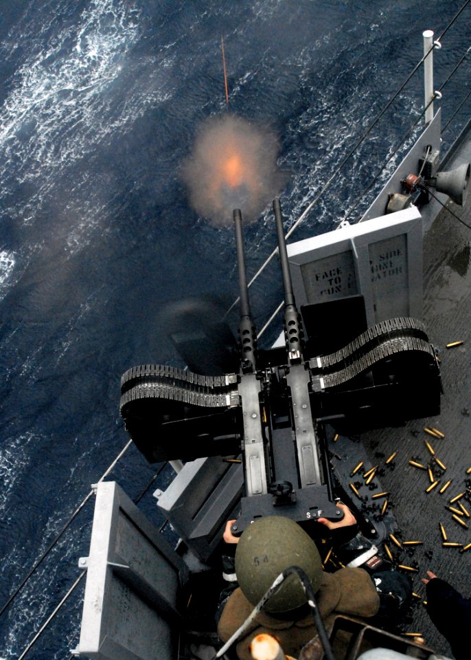 US Navy 080209-N-5067K-299 A gunner stationed aboard the amphibious transport dock ship USS Juneau (LPD 10) fires a twin 50-caliber machine-gun during a live fire training exercise