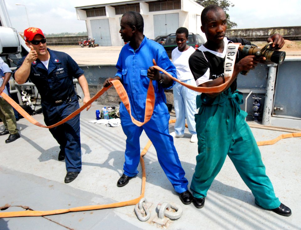 US Navy 080212-N-4044H-086 Damage Controlman 1st Class Adam Burg explains to Ghananian sailors the proper way to walk with the nozzle of a hose during a damage control exercise provided by Africa Partnership Station aboard a Gh