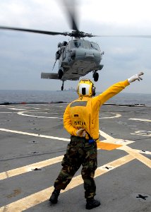 US Navy 080212-N-5067K-247 Aviation Boatswains Mate (Helicopters) Airman, Kevin A. Bourne directs an MH-60S Seahawk after take-off from the flight deck of the amphibious transport dock USS Juneau (LPD 10) during deck landing qu