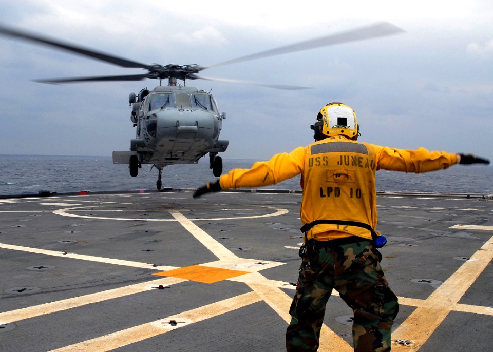 US Navy 080212-N-5067K-280 Aviation Boatswain's Mate (Fuels) Airman, Lowel A. Shorey III directs an MH-60S Seahawk during deck landing qualifications on the flight deck aboard the amphibious transport dock USS Juneau (LPD 10)