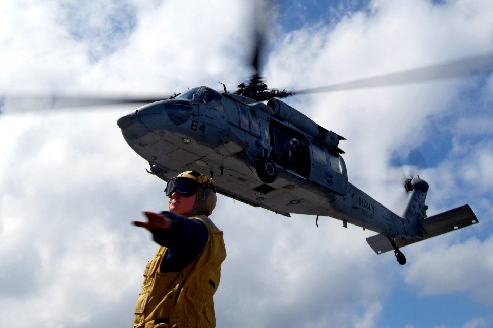 US Navy 080216-N-0807W-535 Boatswain's Mate 2nd Class Michael J. Ficocelli, a landing signalman enlisted assigned to the dock landing ship USS Harpers Ferry (LSD 49), directs an MH-60S Seahawk
