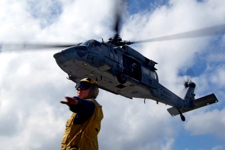 US Navy 080216-N-0807W-535 Boatswain's Mate 2nd Class Michael J. Ficocelli, a landing signalman enlisted assigned to the dock landing ship USS Harpers Ferry (LSD 49), directs an MH-60S Seahawk