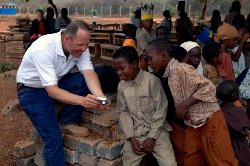 US Navy 080218-F-6318R-044 U.S. Navy Capt. John R. Andresen, team chief for the 354th Civil Affairs Brigade Functional Specialty Team, shows Manda Bay Primary School students a photo of themselves on his camera