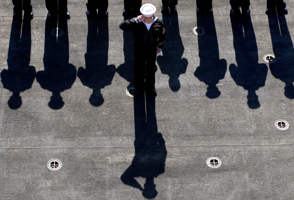 US Navy 080211-N-0640K-015 A Sailor aboard the Nimitz-class aircraft carrier USS Ronald Reagan (CVN 76) renders a hand salute during a burial-at-sea ceremony for nine military veterans photo