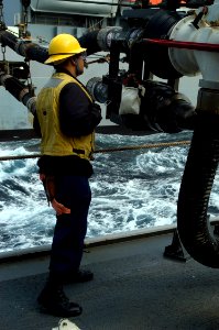 US Navy 080218-N-5253W-003 Boatswain's Mate 3rd Class William Yu monitors the flow of fuel from the Military Sealift Command fleet replenishment oiler USNS Rappahannock (T-AO 204) during a refueling at sea