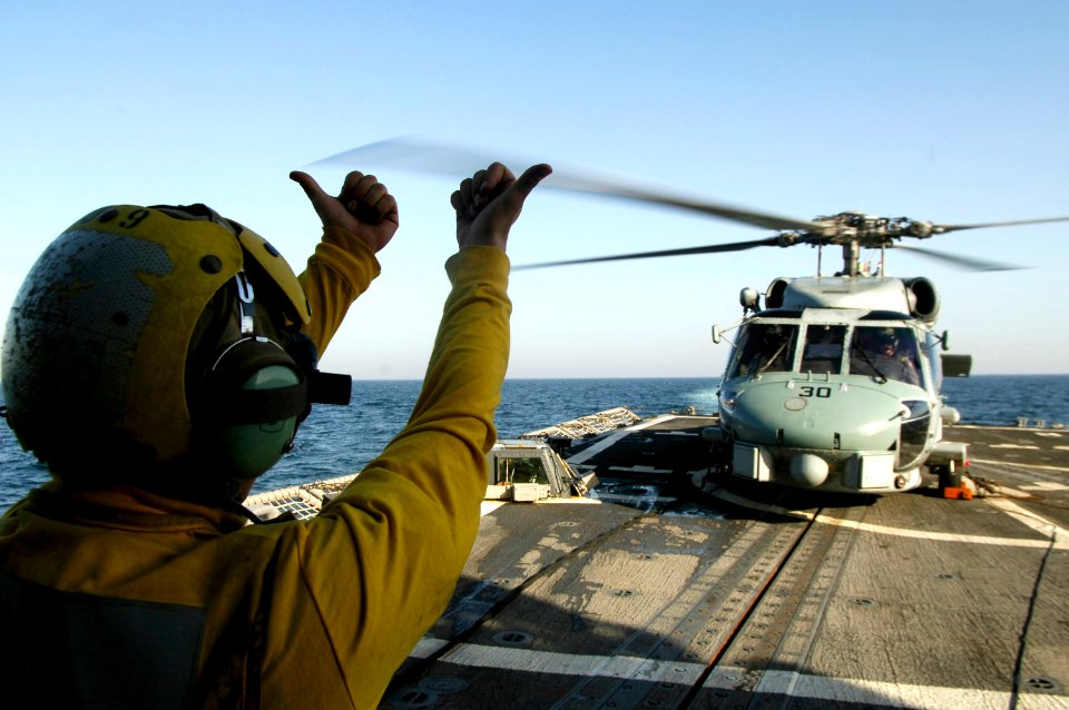 US Navy 080215-N-2420K-139 Boatswain's Mate 3rd Class Christian Anton, a landing signalman enlisted, gives hand signals to the pilot of an SH-60B Seahawk