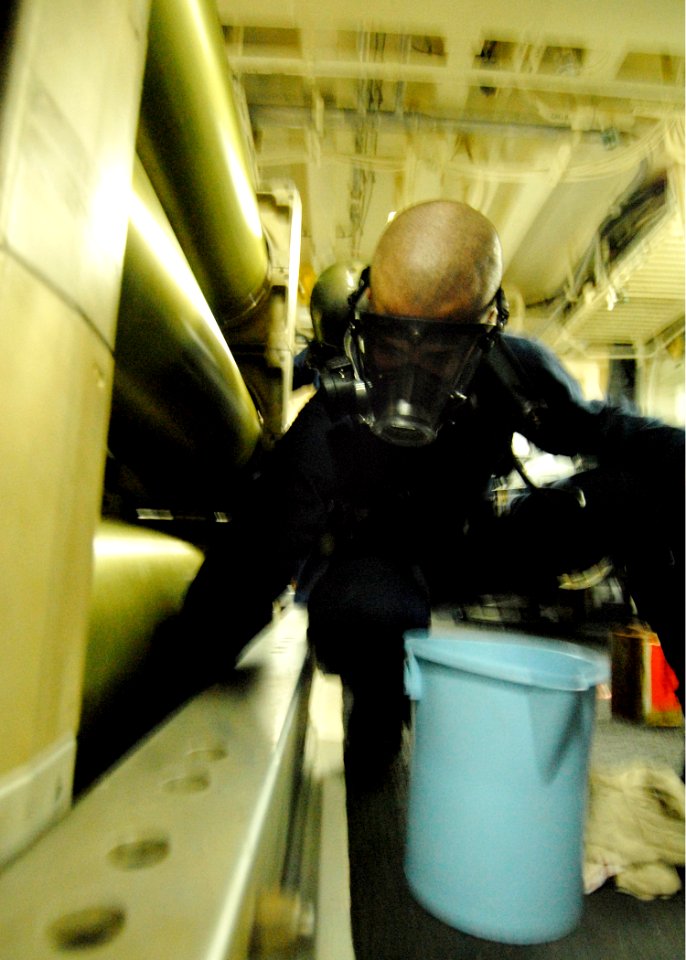 US Navy 080215-N-5476H-022 Gunner's Mate 2nd Class Joshua Shirey, a native of Ridgway, Penn., simulates cleaning fuel spill during a damage control drill in the torpedo magazine aboard the guided missile cruiser USS Lake Erie (