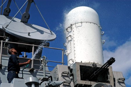 US Navy 080214-N-9123L-006 Fire Controlman 2nd Class Brent Johnson hoses down the forward close-in weapons system (CIWS) aboard the guided-missile destroyer USS John S. McCain (DDG 56)
