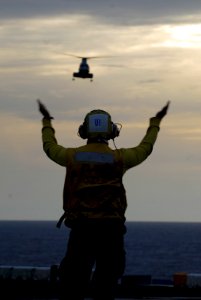 US Navy 080219-N-4010S-151 A landing signal officer directs a helicopter to the flight deck of the amphibious assault ship USS Essex (LHD 2)