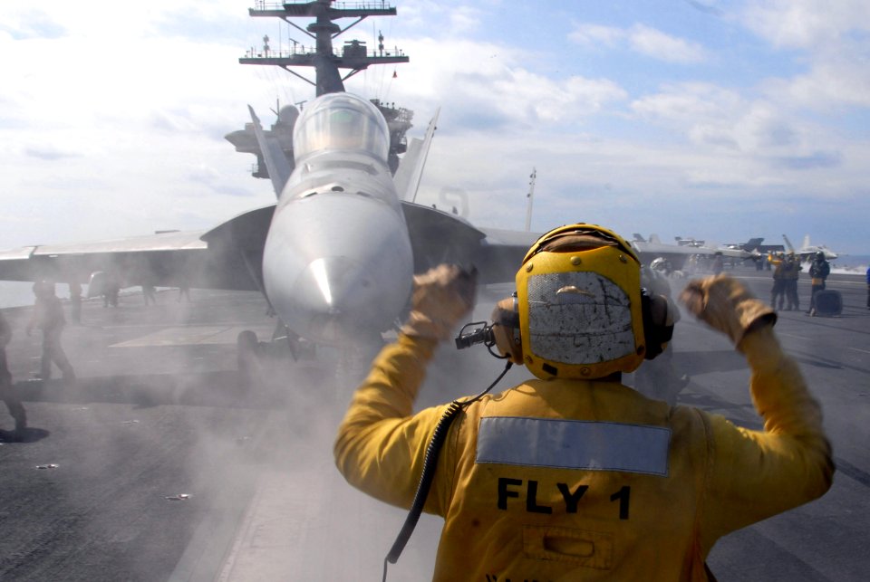 US Navy 080219-N-6326B-027 Aviation Boatswain's Mate (Handling) 3rd Class Jerell Hurdle directs an F-A-18F Super Hornet to a during flight operations aboard the aircraft carrier USS Nimitz (CVN 68)