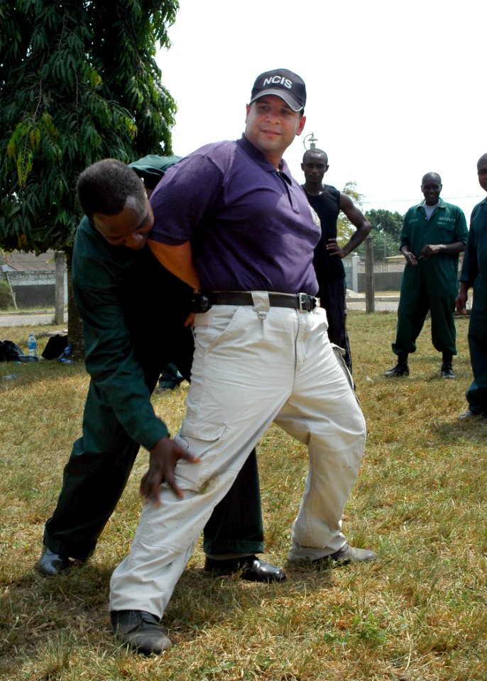 US Navy 080212-N-0577G-015 Africa Partnership Station (APS) instructor Chief Master-At-Arms Felix Rivera of Coral Springs, Fla. is handcuffed and checked for weapons by a student from the Ghanaian Port Authority during a lesson