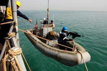 US Navy 080218-N-2420K-040 Damage Controlman 3rd Class Matthew Villafuerte, a member of the guided-missile frigate USS Ingraham (FFG 61) visit, board, search and seizure team, secures a machine gun to its mount on a rigid-hull