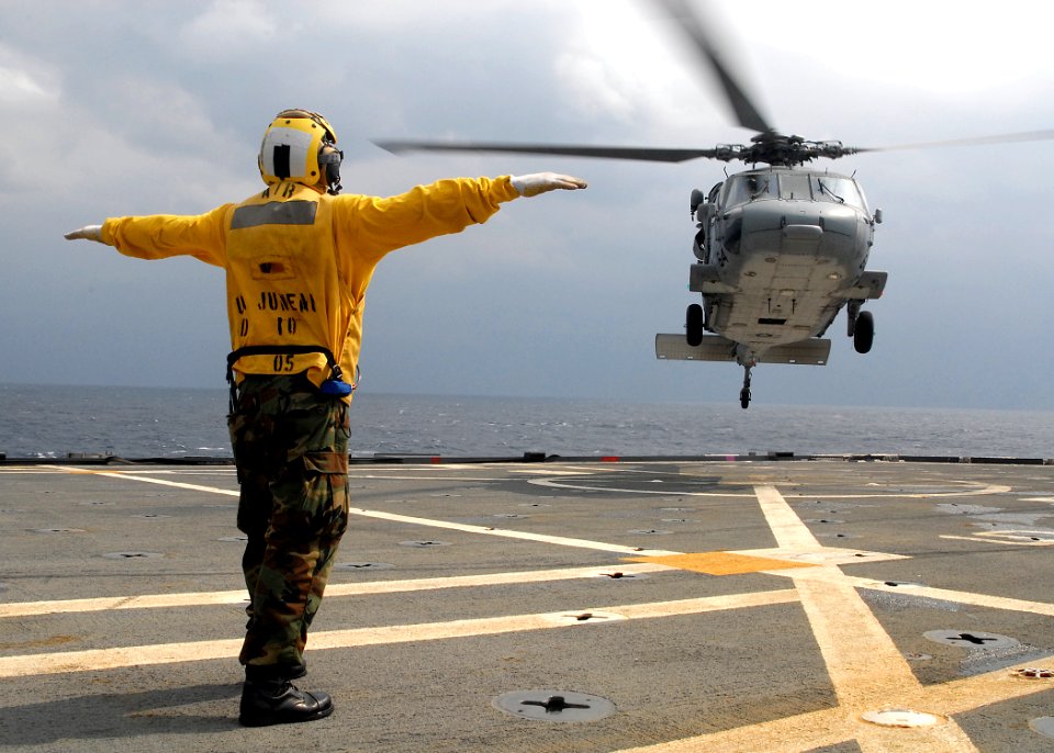 US Navy 080212-N-5067K-443 Aviation Boatswain's Mate (Helicopters) Airman, Kevin A. Bourne directs an MH-60S Seahawk during deck landing qualifications on the flight deck aboard the amphibious transport dock USS Juneau (LPD 10)