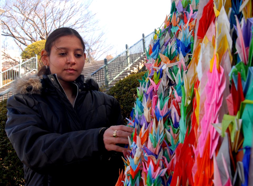 US Navy 080213-N-6326B-140 Operations Specialist 3rd Class Rae Reyes, assigned to the aircraft carrier USS Nimitz (CVN 68), admires a display of 1,000 origami paper cranes while touring the grounds of the Nagasaki Atomic Bomb M
