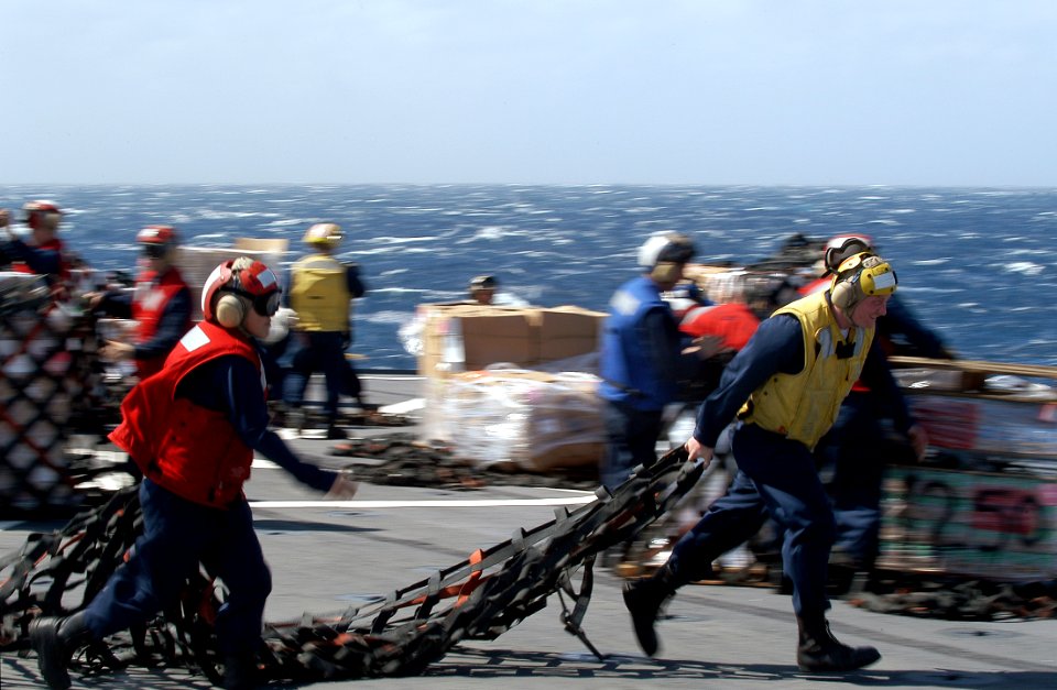US Navy 080216-N-0807W-245 Boatswain's Mate 2nd Class Lawerence A. Ferguson, right, and Damage Control Fireman Janet Pena, assigned to the dock landing ship USS Harpers Ferry (LSD 49), move cargo nets off the flight deck