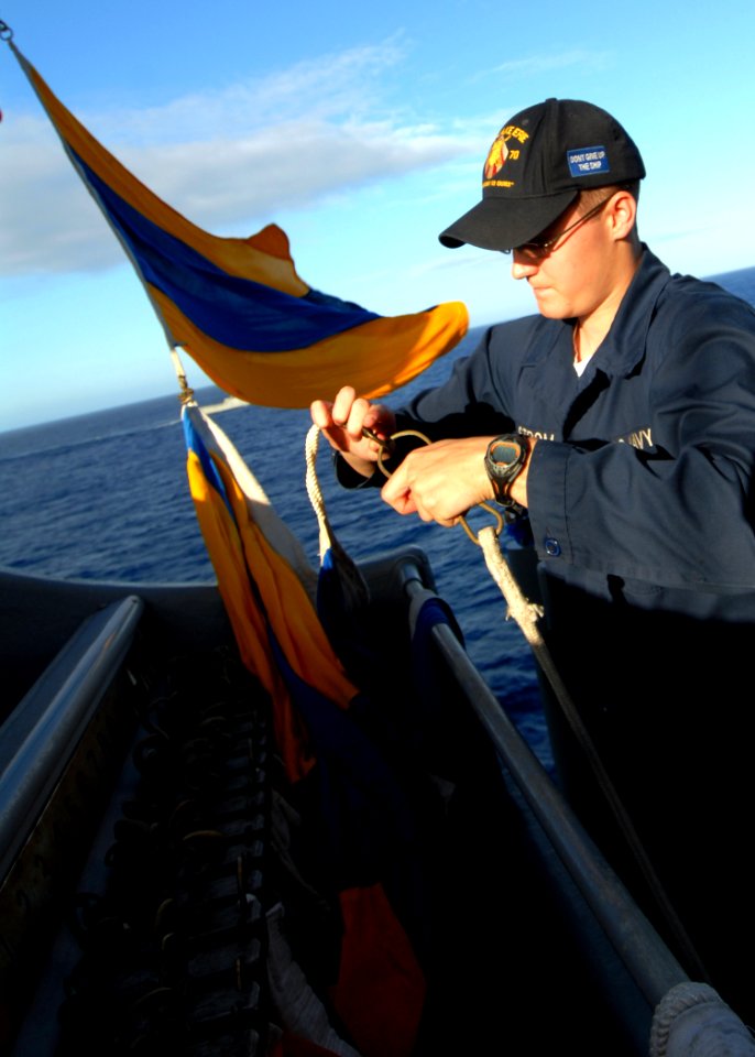 US Navy 080218-N-5476H-132 Quartermaster Seaman Jason Strom, a native of Brandon, Minn., attaches a signal flag to be hoisted up during a signaling drill between the guided-missile cruiser USS Lake Erie (CG 70)
