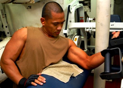 US Navy 080217-N-5476H-081 Store Keeper 2nd Class Rafael Alexander, a native of Honolulu, Hawaii, lifts weights using the bicep curl machine in the weight room of the guided-missile cruiser USS Lake Erie (CG 70)