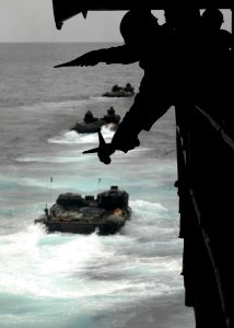 US Navy 080218-N-5067K-191 Seaman Keanne Q. Douglas crosses his wands to signal a Marine amphibious assault vehicle to hold position during a launch from the well deck of the amphibious transport dock USS Juneau (LPD 10)