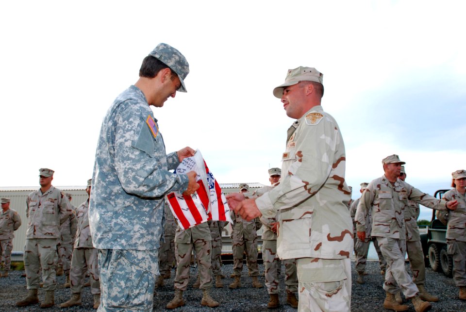 US Navy 080528-A-6489K-051 embers of the Coast Guard's Port Security Unit 313 presents Army Brig. Gen. Gregory Zanetti, deputy commander, Joint Task Force Guantanamo, a Coast Guard flag to keep in remembrance of the unit photo