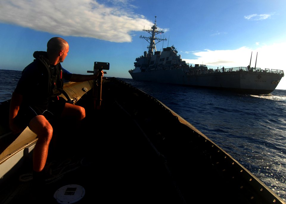US Navy 080218-N-5476H-077 Operations Specialist 2nd Class Brendon Pacheco braces himself as a rigid hull inflatable boat from the guided-missile cruiser USS Lake Erie (CG 70) makes an approach toward the guided-missile destroy
